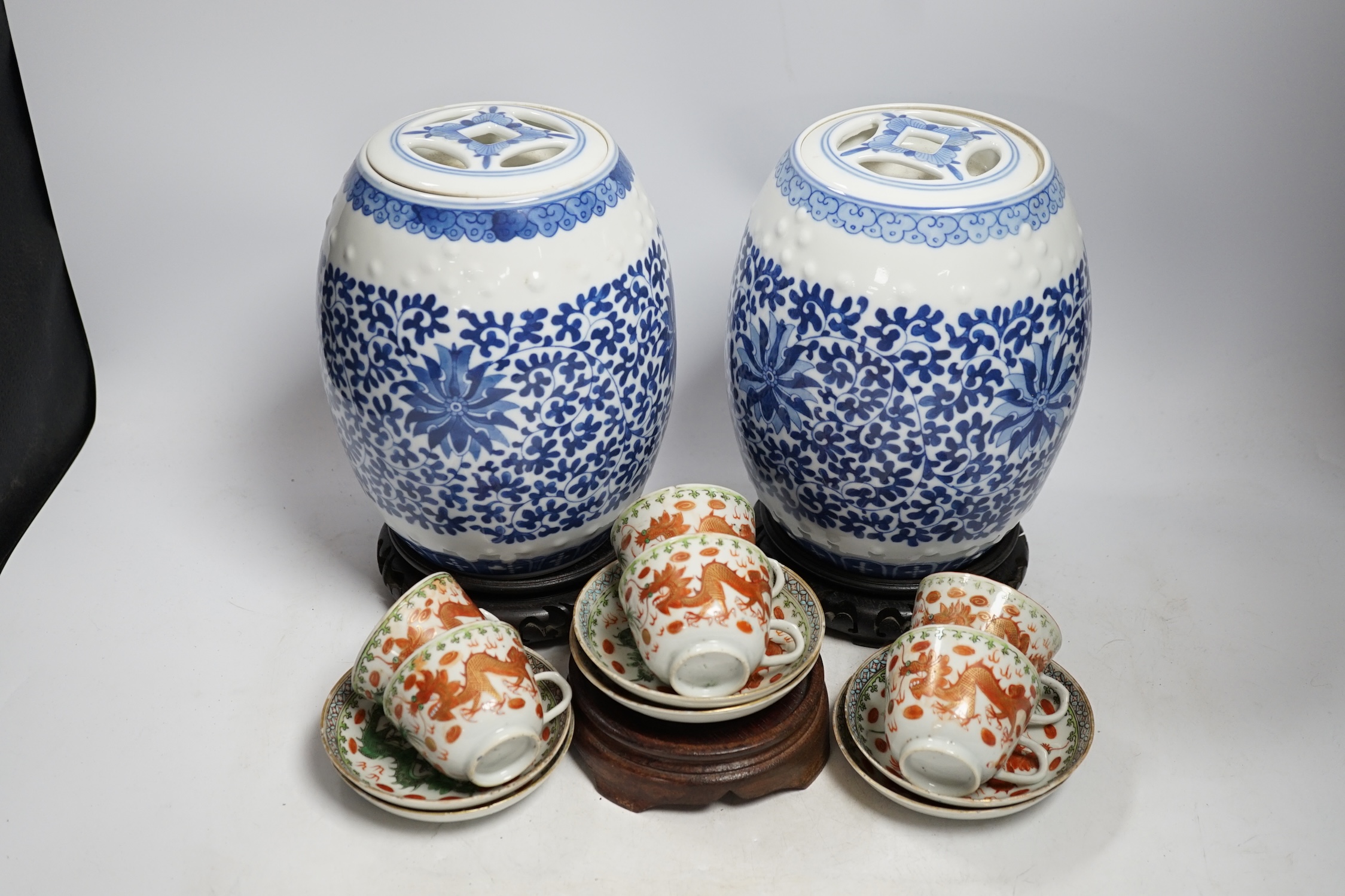 A pair of Chinese blue and white barrel jars, various cups and saucers and three hardwood stands, largest 21cm high